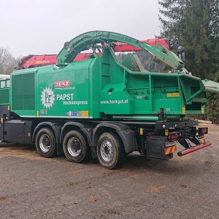 Ein großer grüner Lkw mit einem großen Kran auf der Ladefläche steht bereit für den Einsatz.